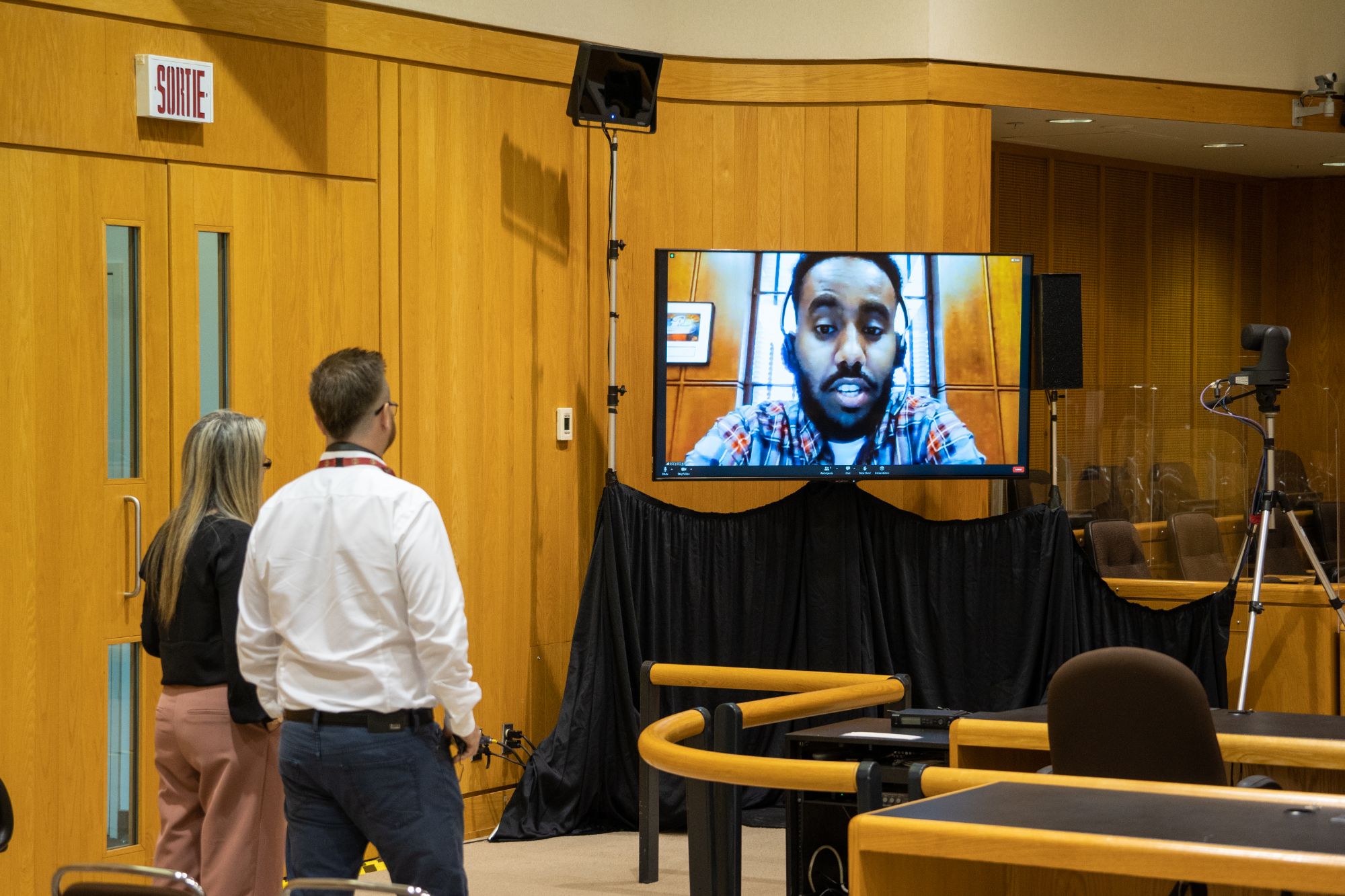 Two employees looking at a TV screen